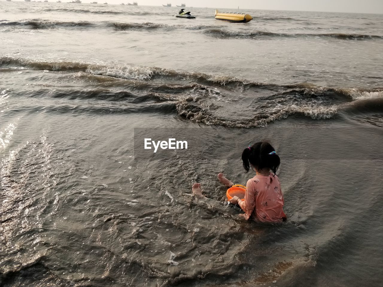 Rear view of girl sitting on beach