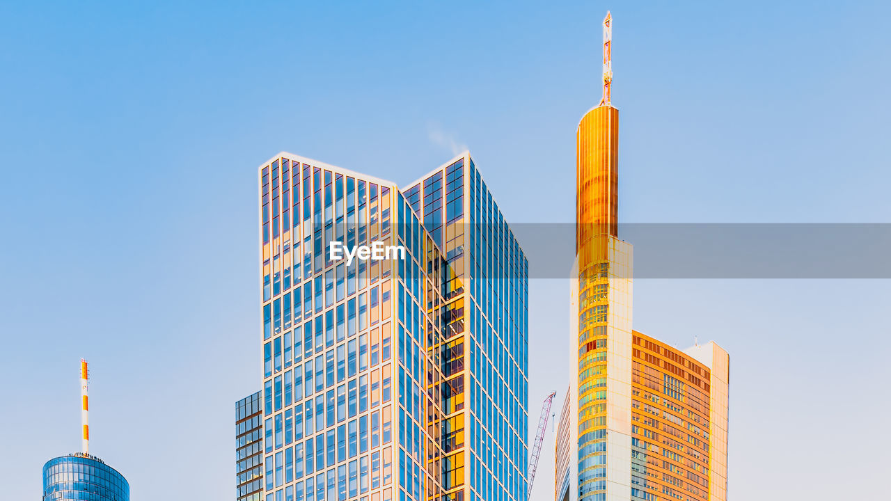 Low angle view of modern buildings against clear blue sky in frankfurt am main, germany