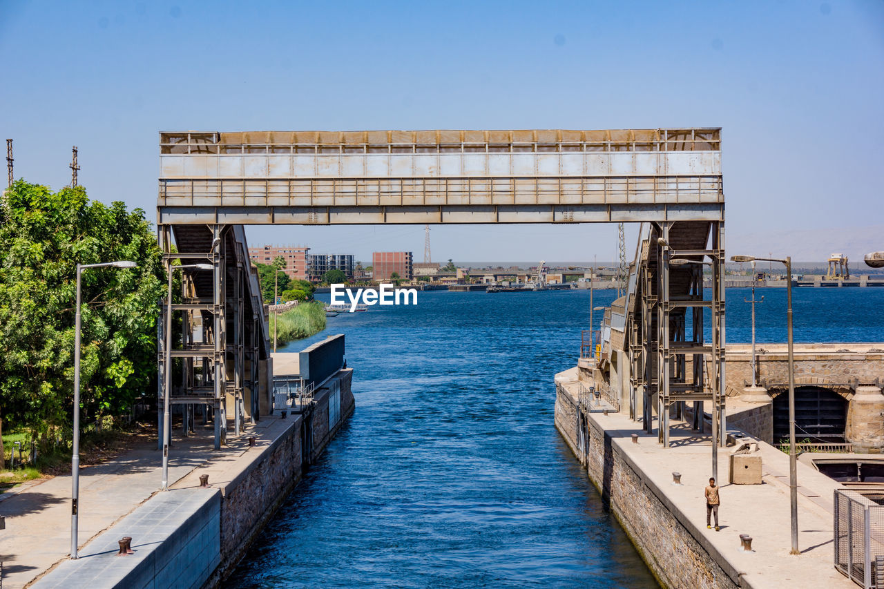 BRIDGE OVER RIVER AGAINST SKY IN CITY