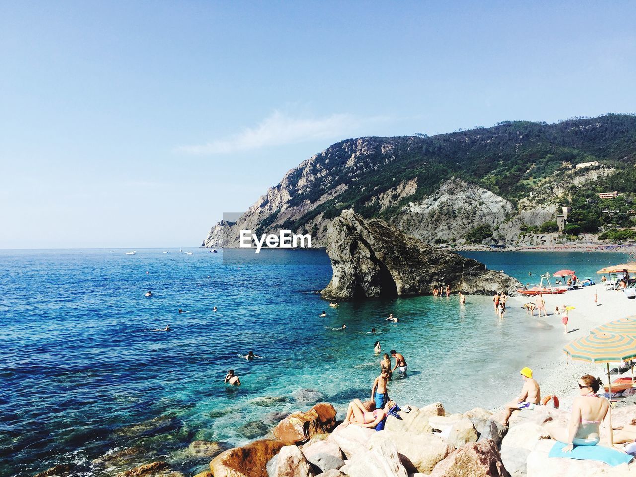 People enjoying at beach against sky