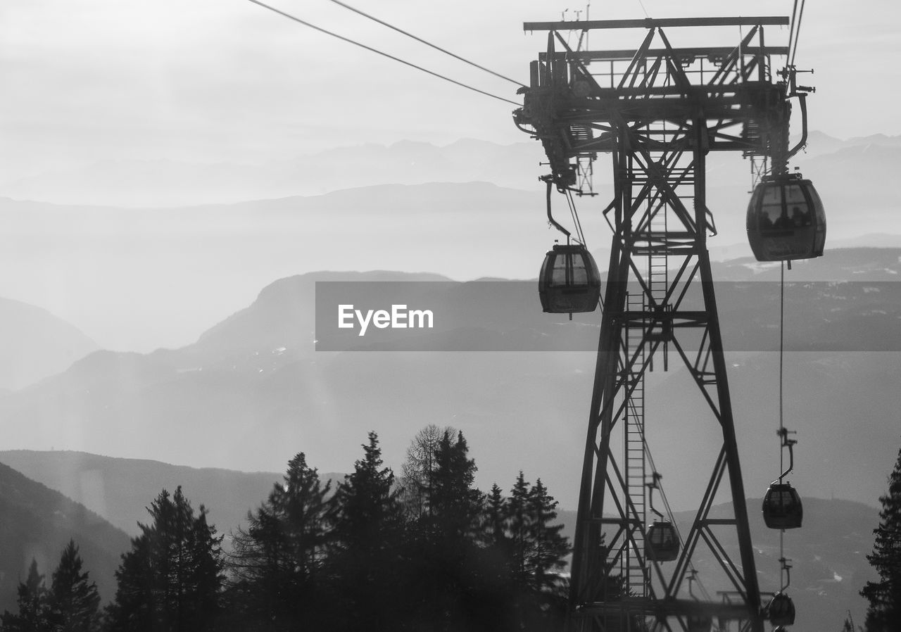mountain, fog, nature, sky, cable car, technology, cable, tree, black and white, no people, monochrome photography, monochrome, plant, scenics - nature, electricity, architecture, mountain range, cloud, outdoors, overhead cable car, beauty in nature, day, snow, built structure, landscape, environment, transportation, land, communication, silhouette, transmission tower