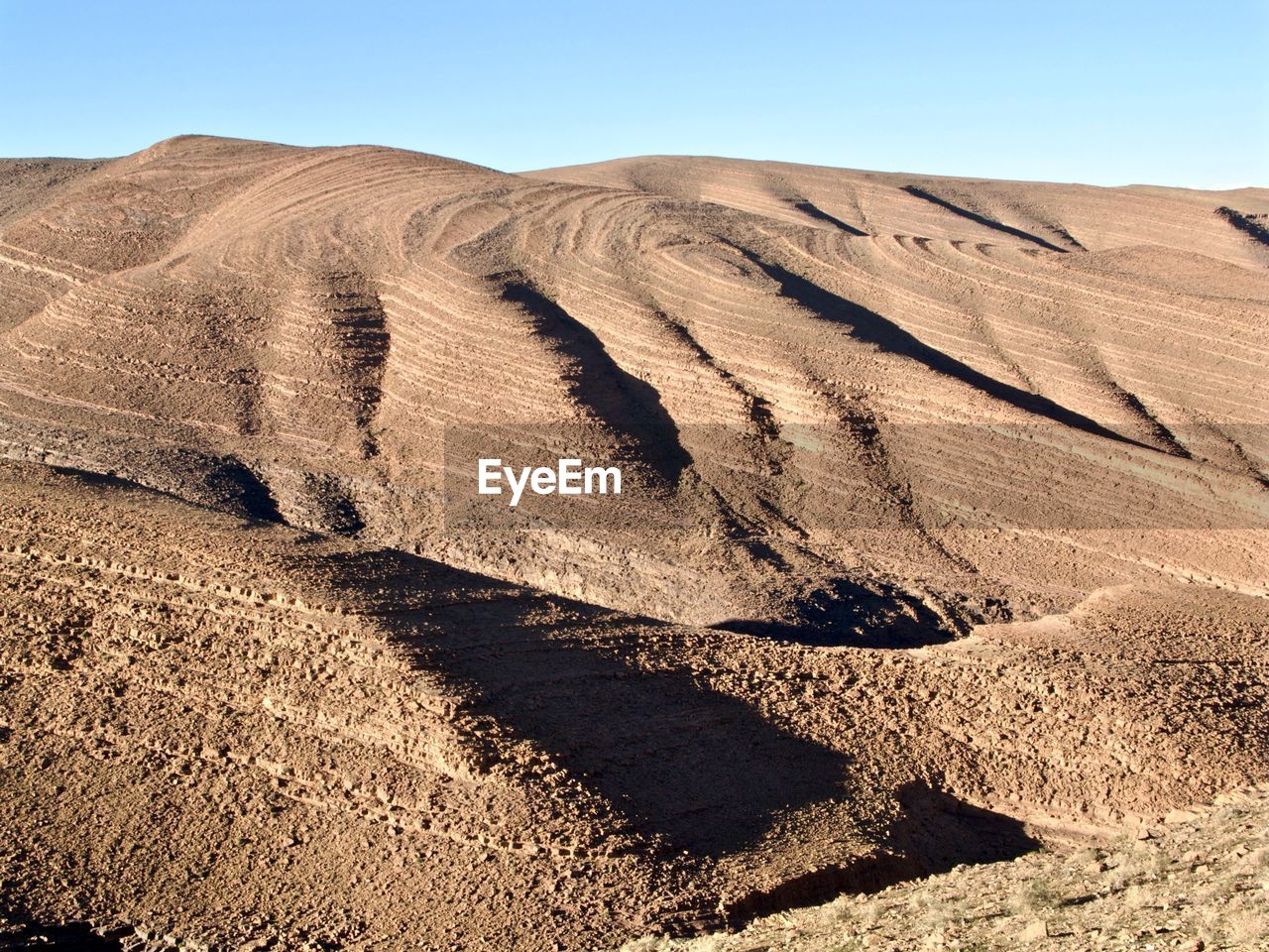 Sand dune in desert against clear sky