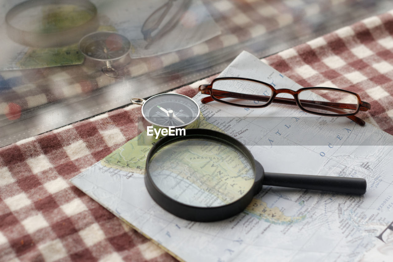 HIGH ANGLE VIEW OF EYEGLASSES ON PAPER