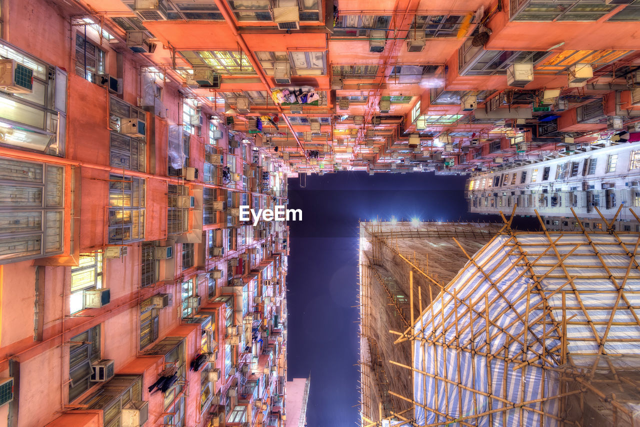 Low angle view of illuminated buildings against sky in city