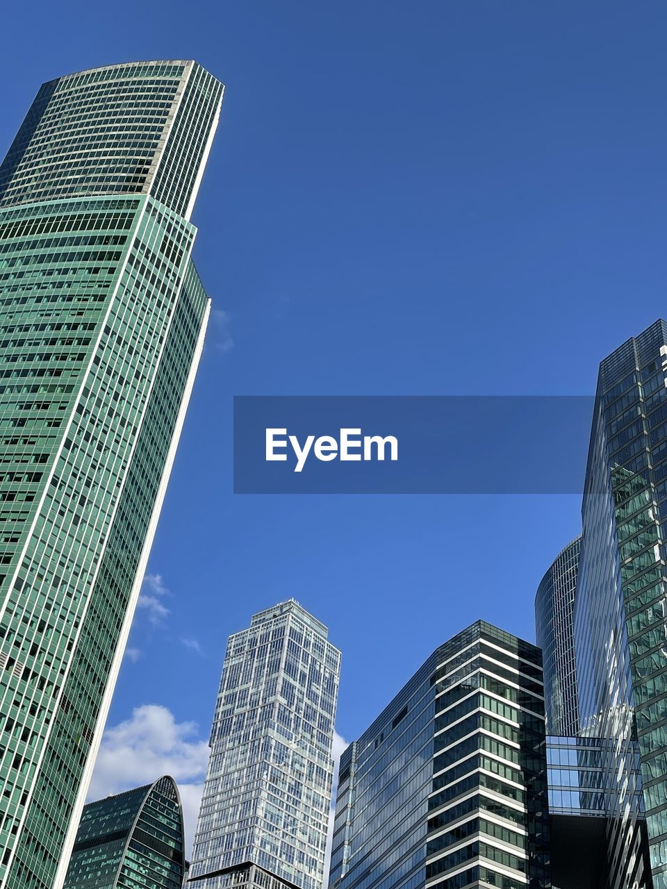 Low angle view of modern buildings against clear blue sky