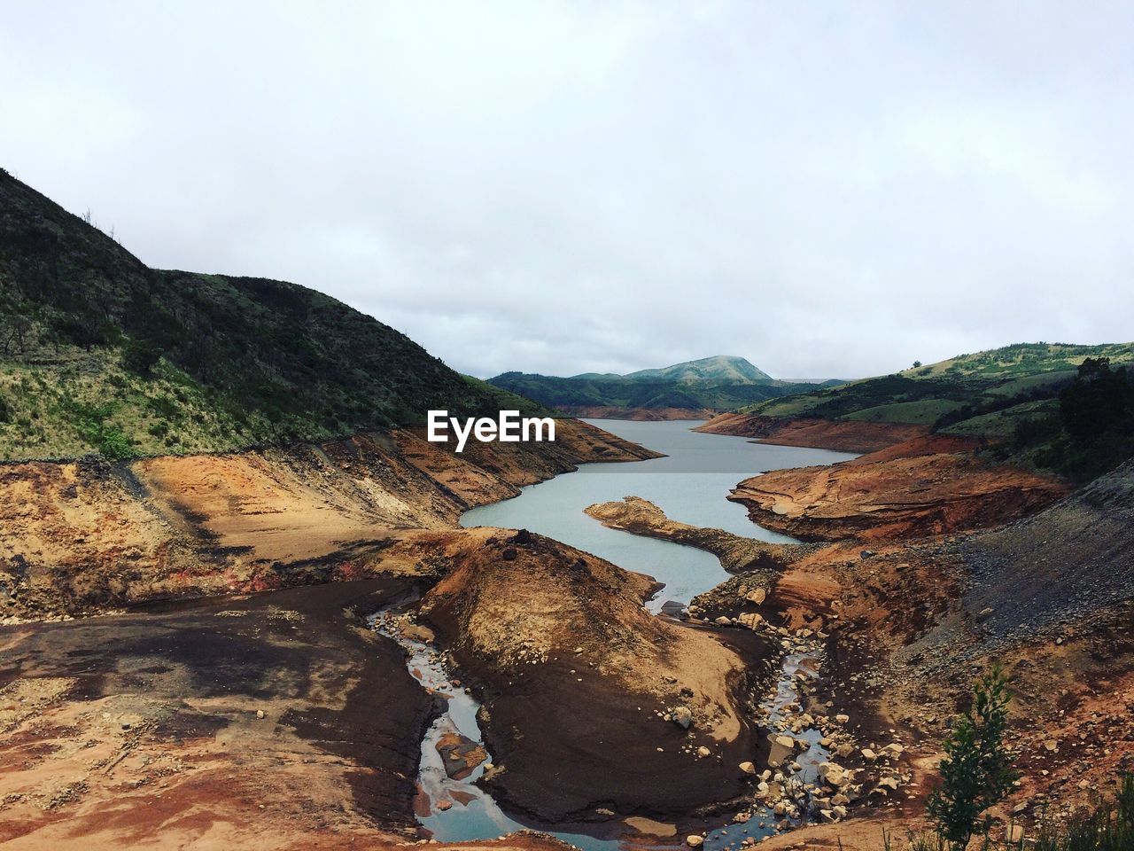 Scenic view of river amidst mountains against sky