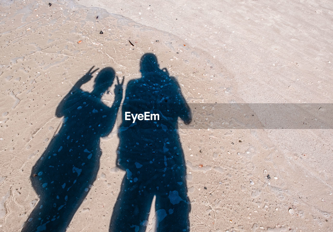 Shadow of couple on sand at beach