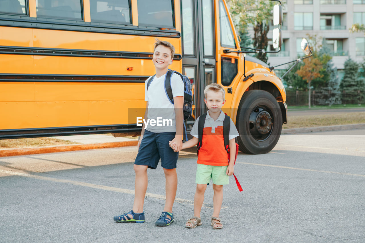 Full length portrait of a smiling boys on road