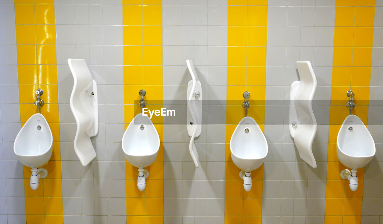 Urinals mounted on wall in public restroom