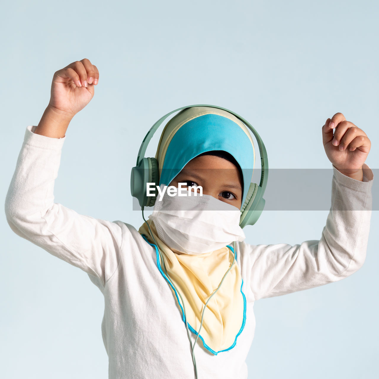 PORTRAIT OF BOY WITH ARMS OUTSTRETCHED AGAINST WHITE BACKGROUND