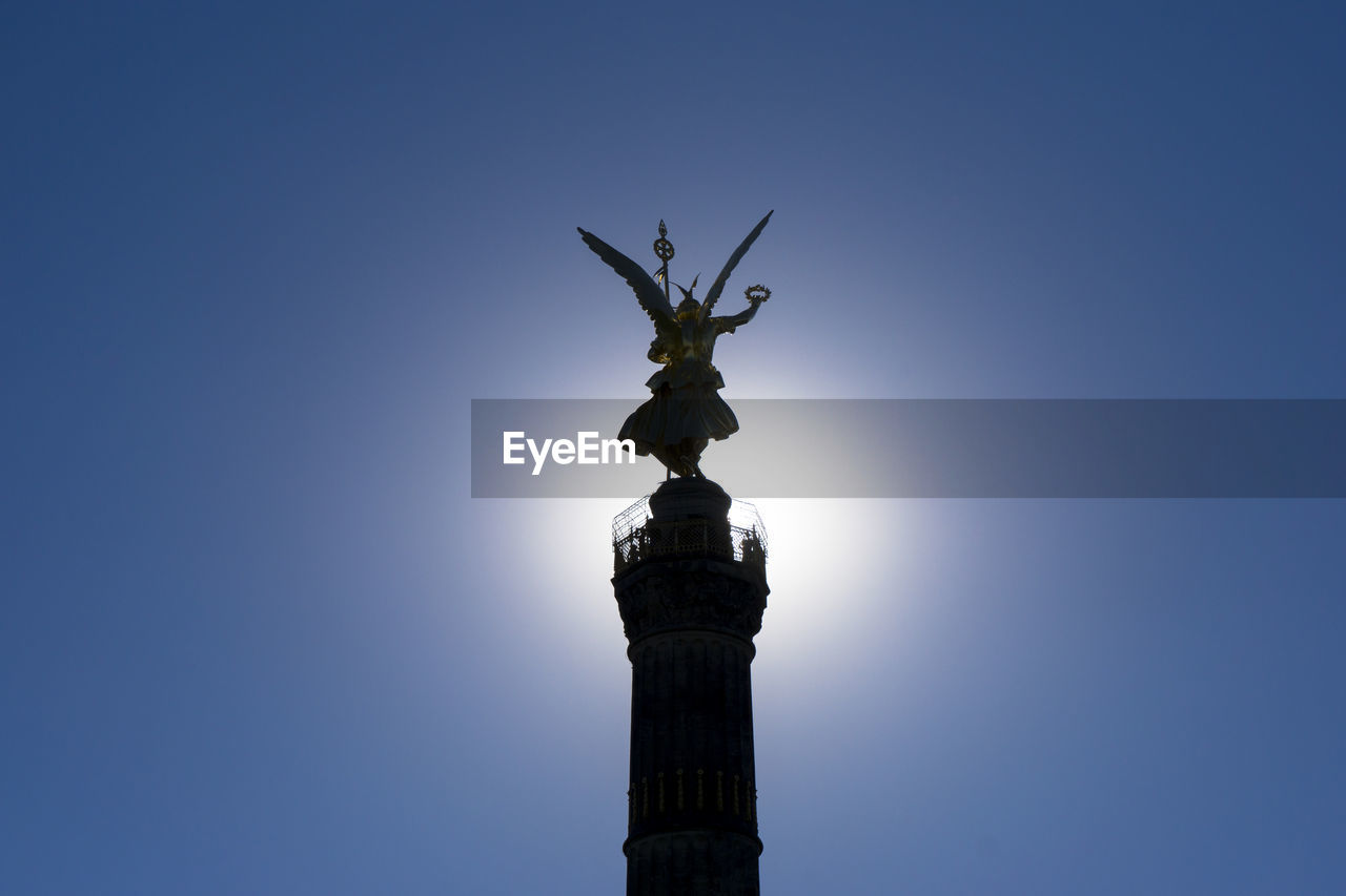 Low angle view of silhouette victory column against clear sky on sunny day