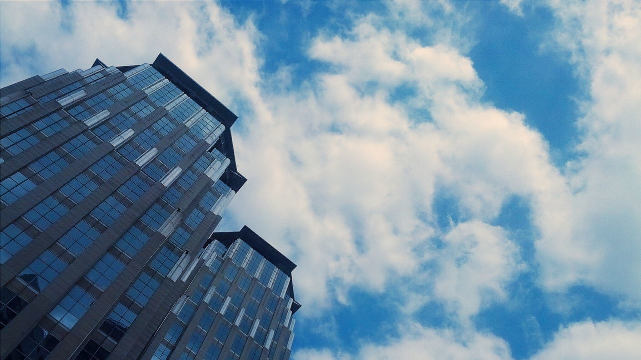 Low angle view of buildings against cloudy sky