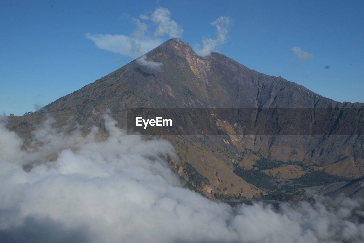 Scenic view of volcanic mountain against blue sky