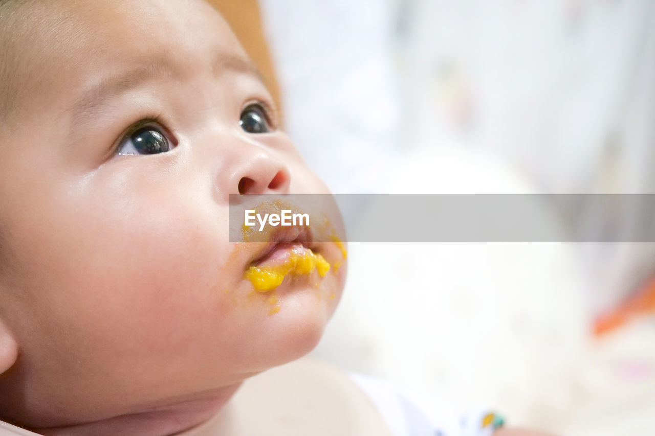 CLOSE-UP PORTRAIT OF CUTE BABY EATING