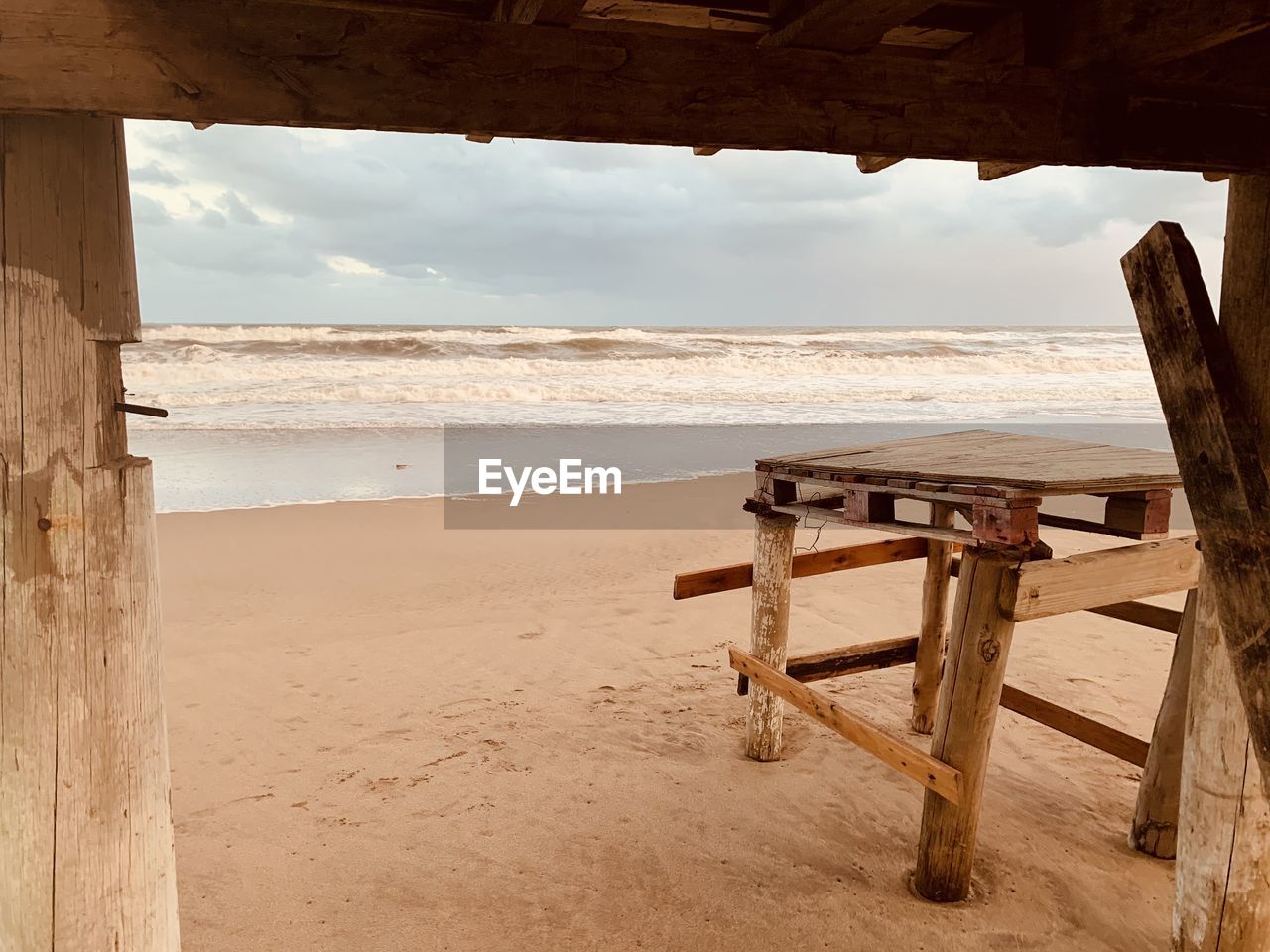 SCENIC VIEW OF SEA AGAINST SKY SEEN THROUGH WOODEN POSTS