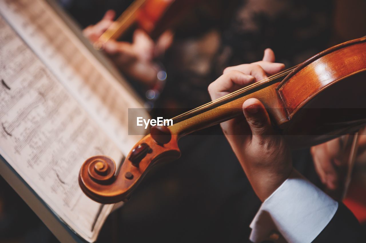 Cropped hand of man playing violin