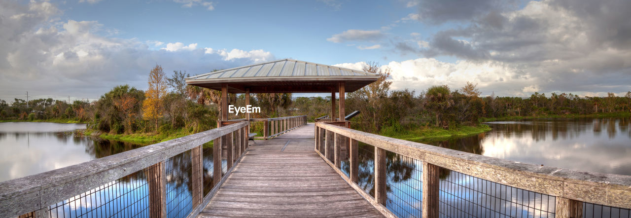 Sunset over gazebo on a wooden secluded, tranquil boardwalk along a marsh pond in freedom park 