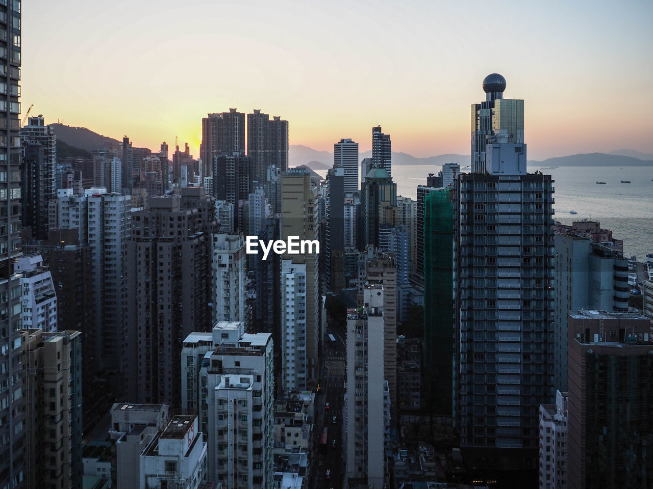 BUILDINGS IN CITY AGAINST SKY AT SUNSET