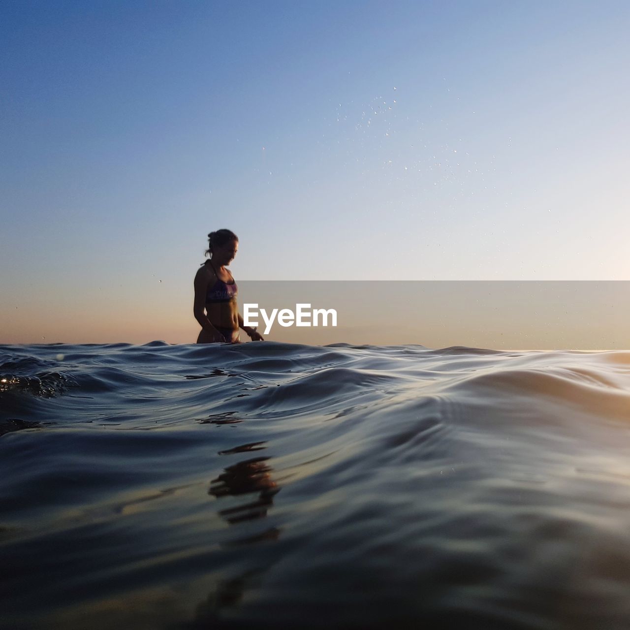 MAN IN SEA AGAINST CLEAR SKY