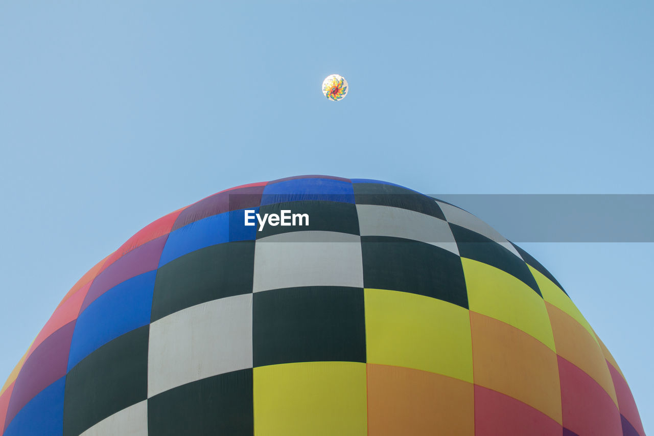 Low angle view of hot air balloon against clear blue sky