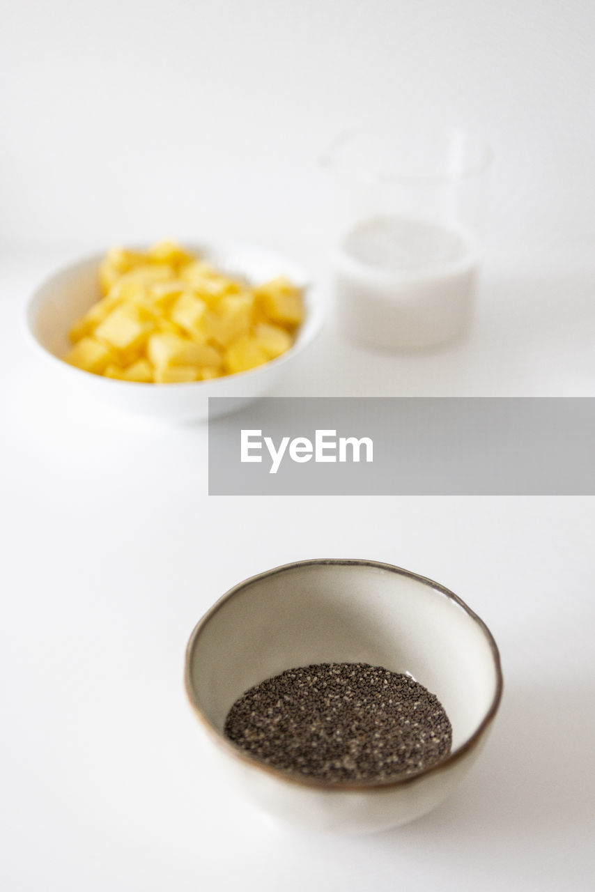 High angle view of mangoes and chia seeds in bowl on table