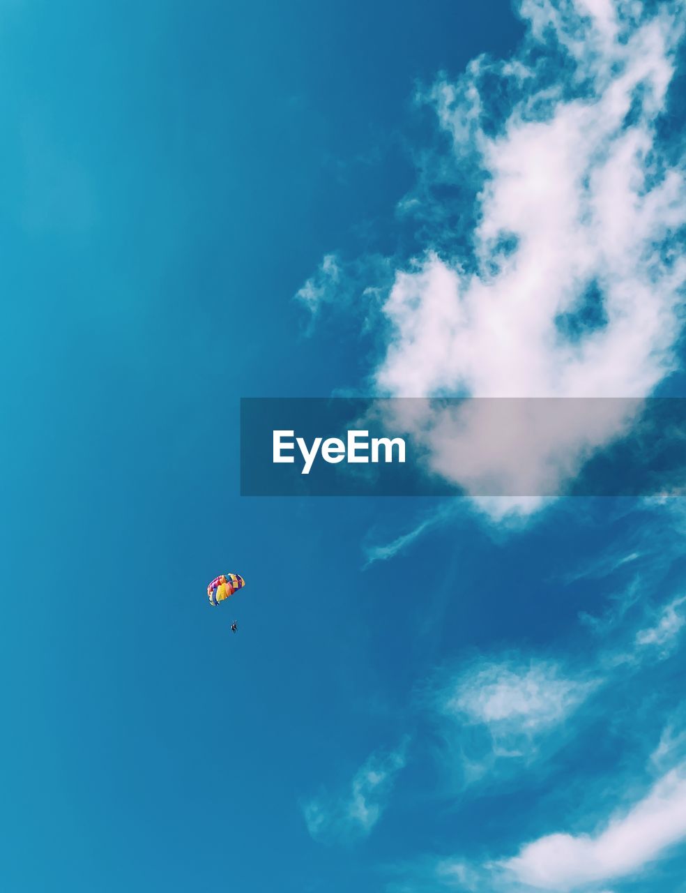 sky, cloud, blue, flying, nature, mid-air, adventure, low angle view, day, extreme sports, parachute, sports, beauty in nature, outdoors, transportation, scenics - nature, parachuting, leisure activity, environment, air vehicle, holiday, paragliding, sea, tranquility, balloon, joy, motion, water, trip, copy space
