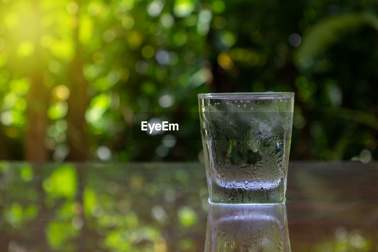 CLOSE-UP OF DRINK IN GLASS ON WATER