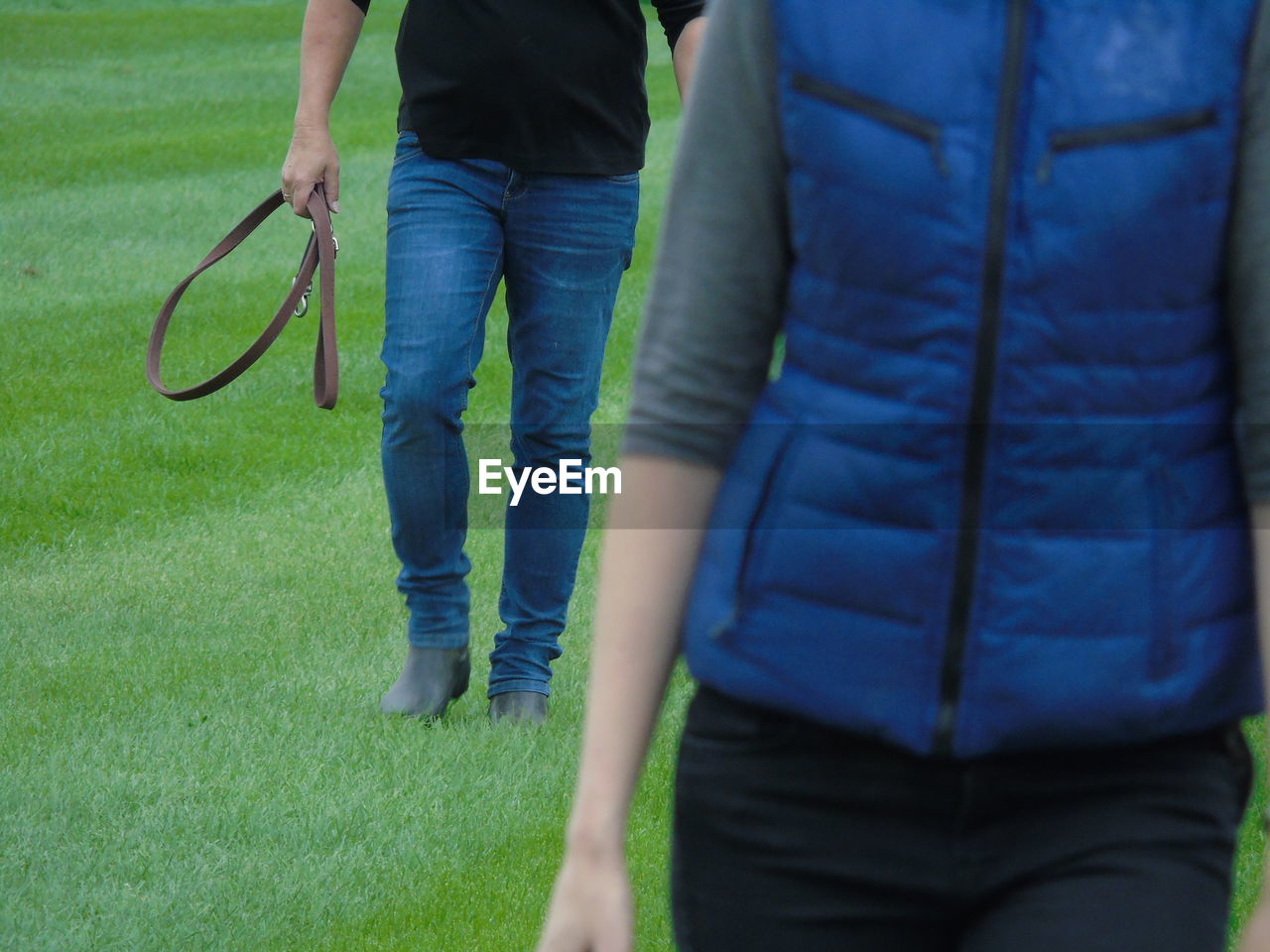 Low section of man and woman walking on grass