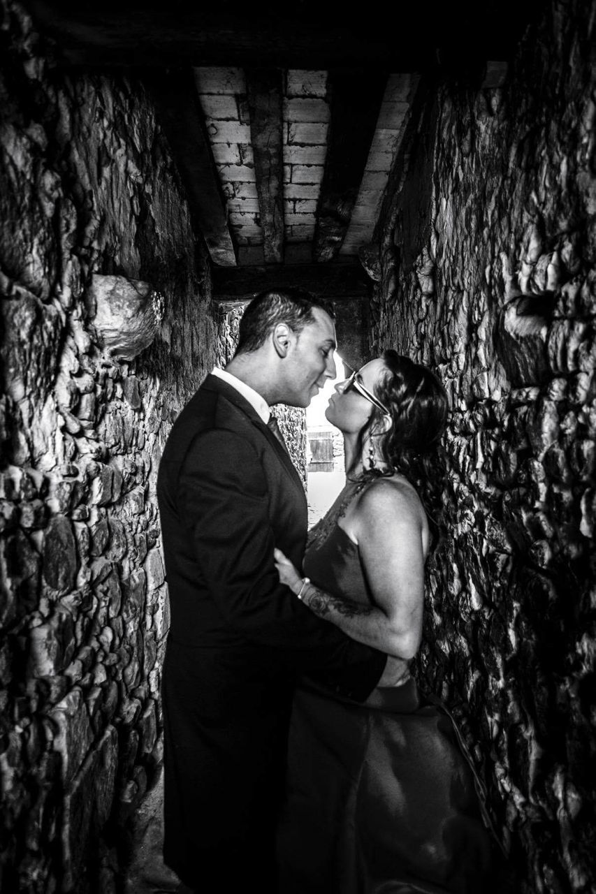 Side view of bride and bridegroom standing amidst walls