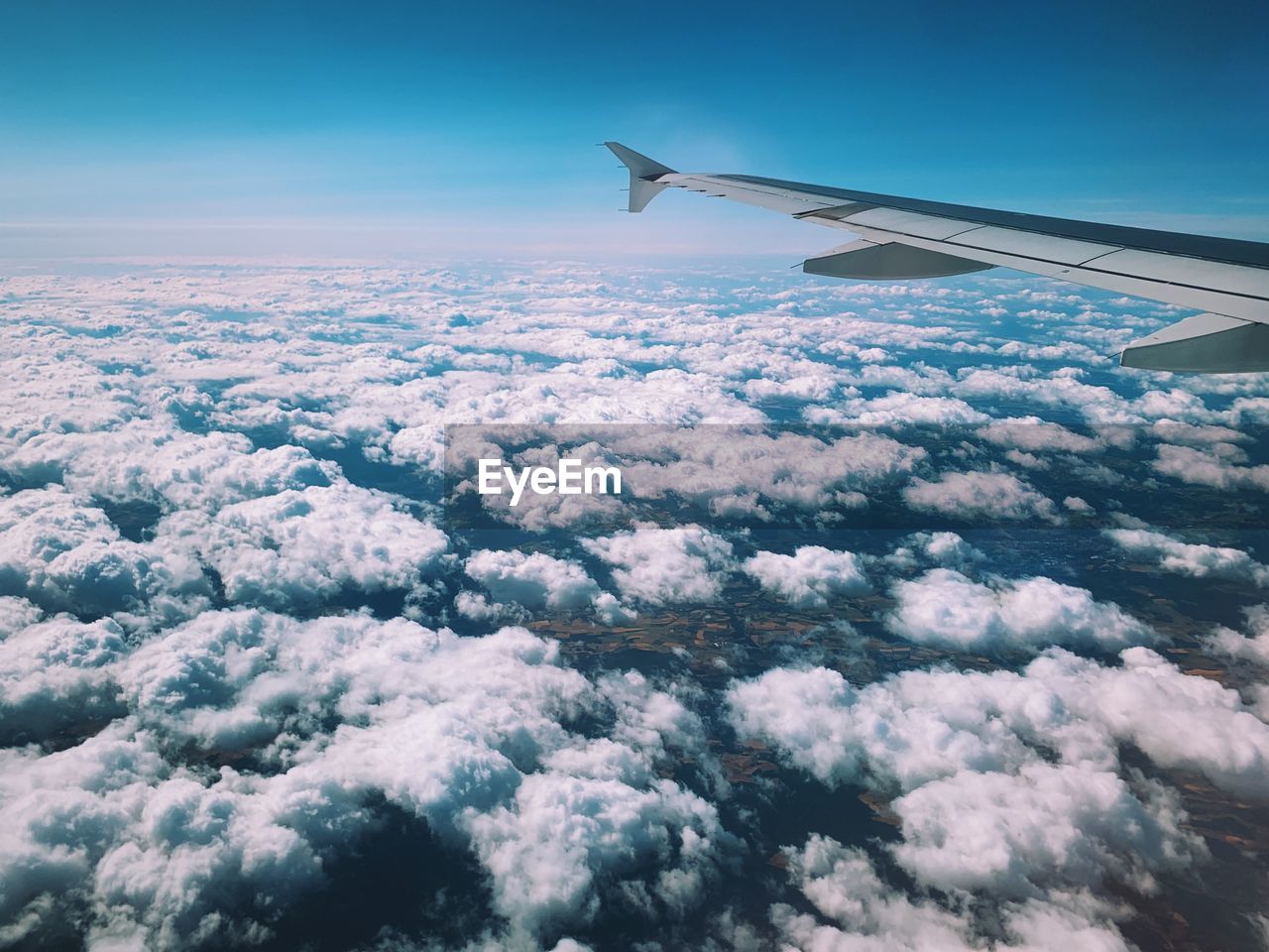 Aircraft wing over cloudscape