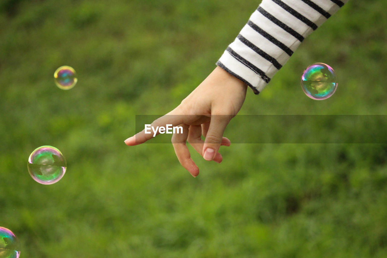 Cropped image of hand pointing at bubble