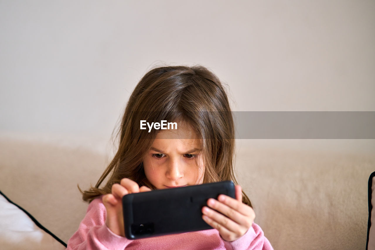 Portrait of girl holding mobile phone