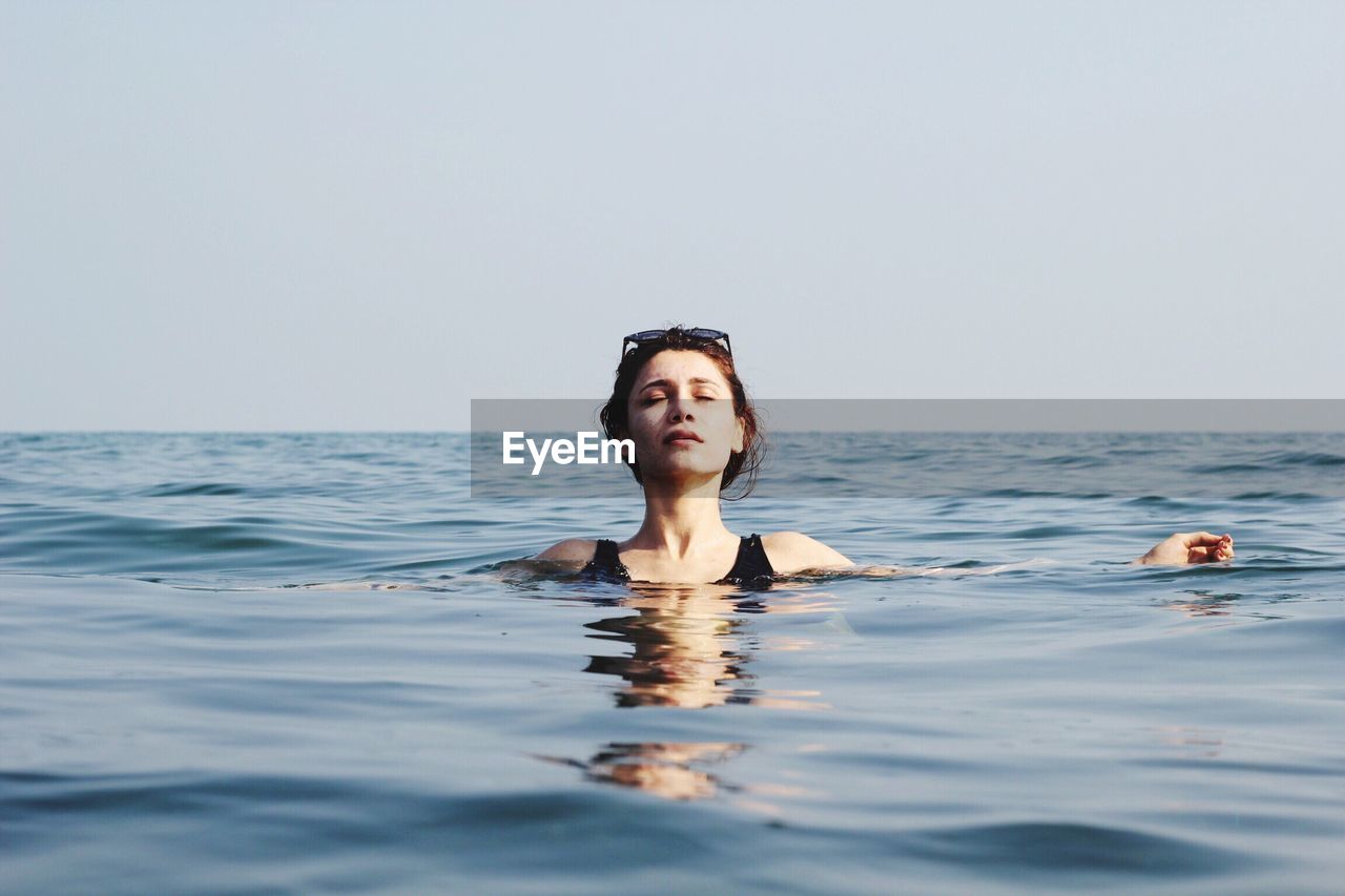 Portrait of young woman swimming in sea