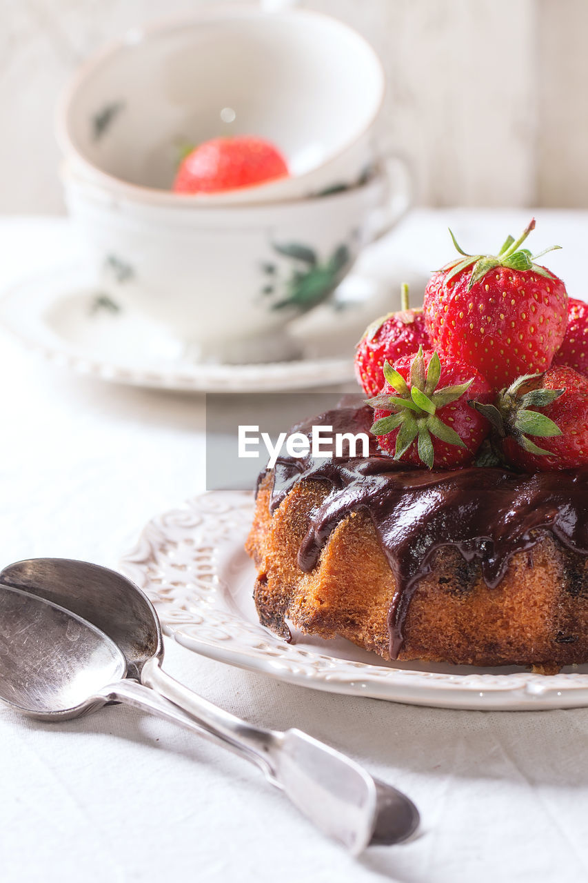 Close-up of fresh cake and strawberries in plate on table