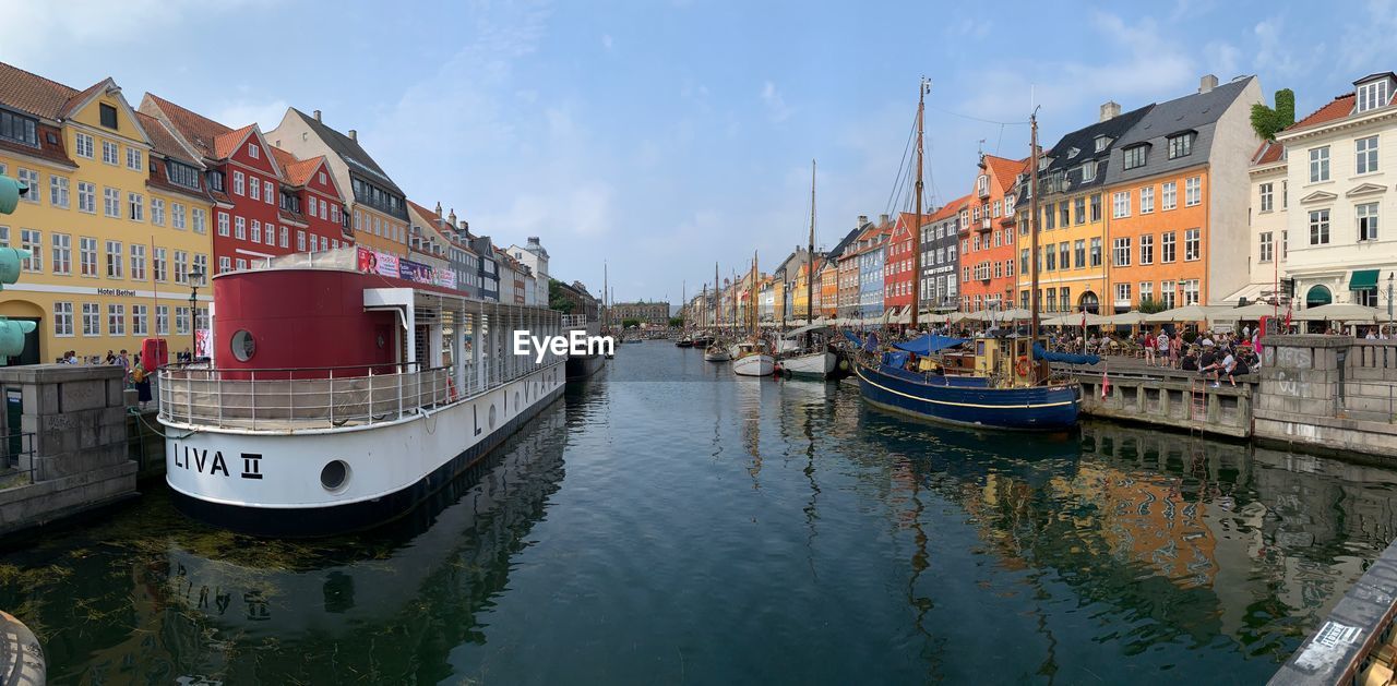 BOATS MOORED IN CANAL AMIDST BUILDINGS IN CITY