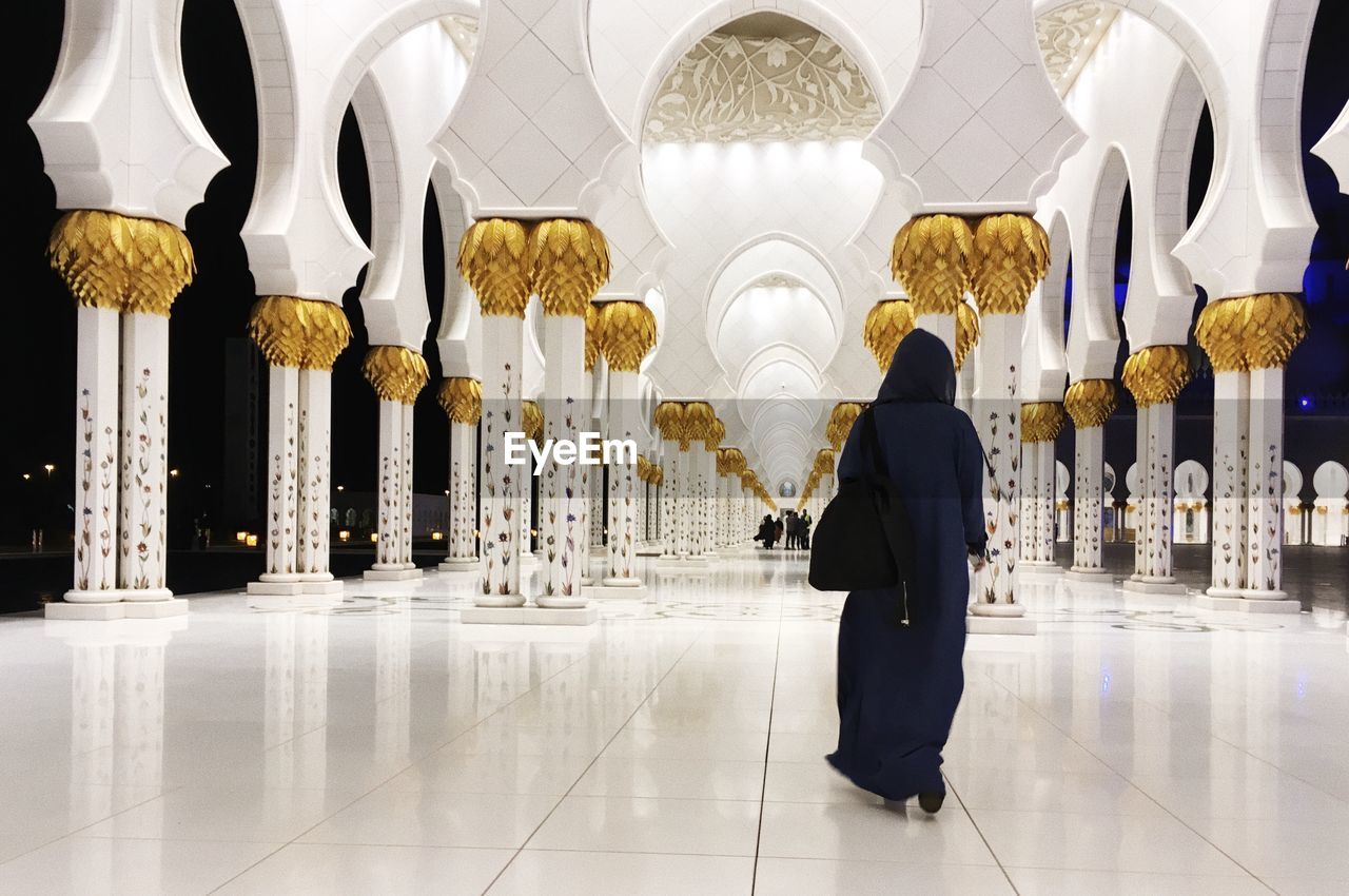 MAN WALKING IN ILLUMINATED TEMPLE