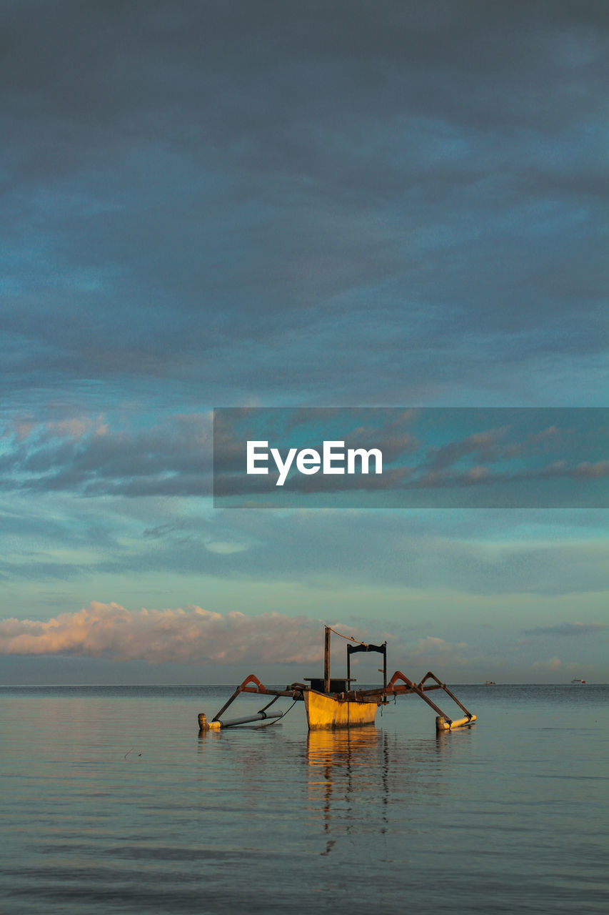 Lone boat in calm sea against the sky