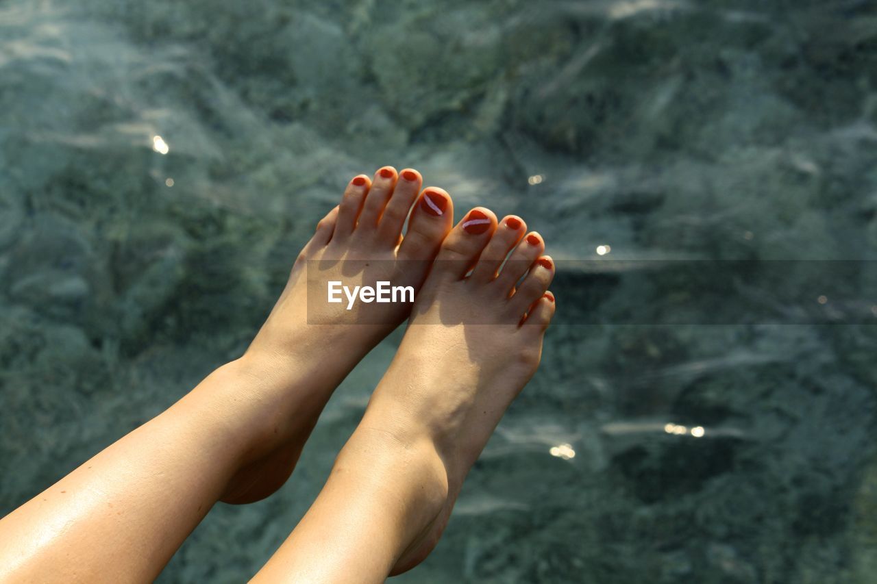 Female feet above water surface