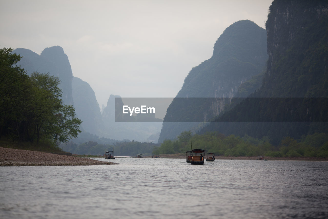 Passenger boats on river in mountains