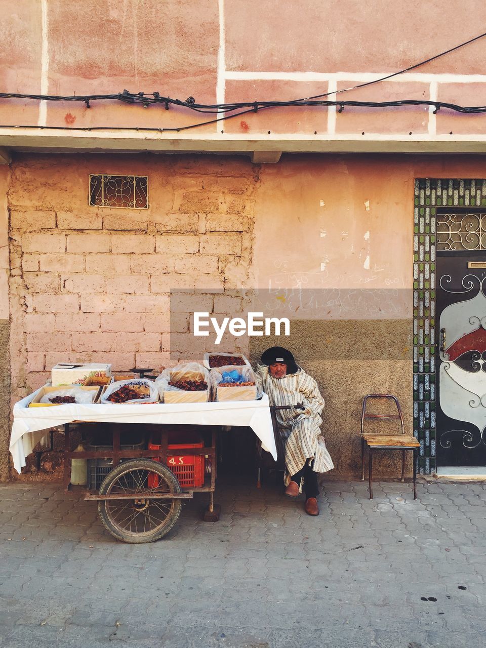 Man selling fruits in front of building