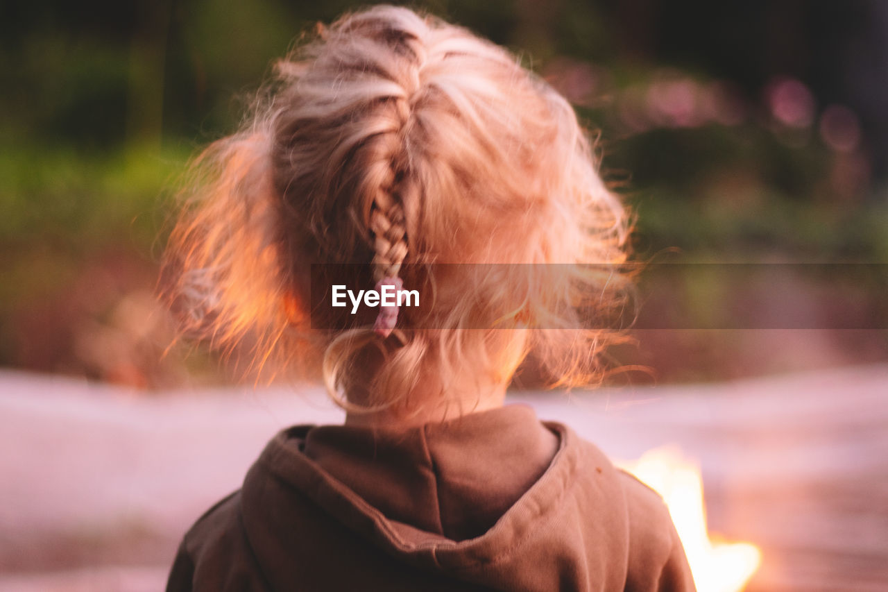 REAR VIEW OF WOMAN STANDING OUTDOORS DURING SUNSET