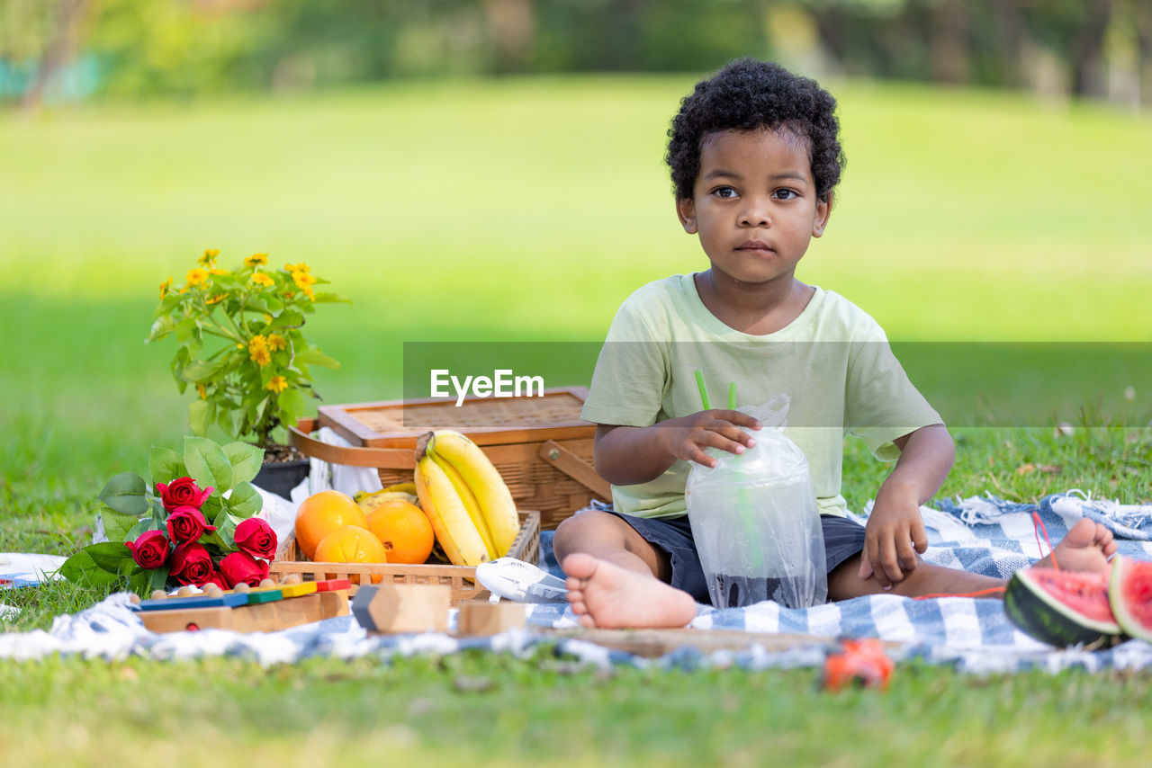 portrait of cute boy playing with vegetables at park