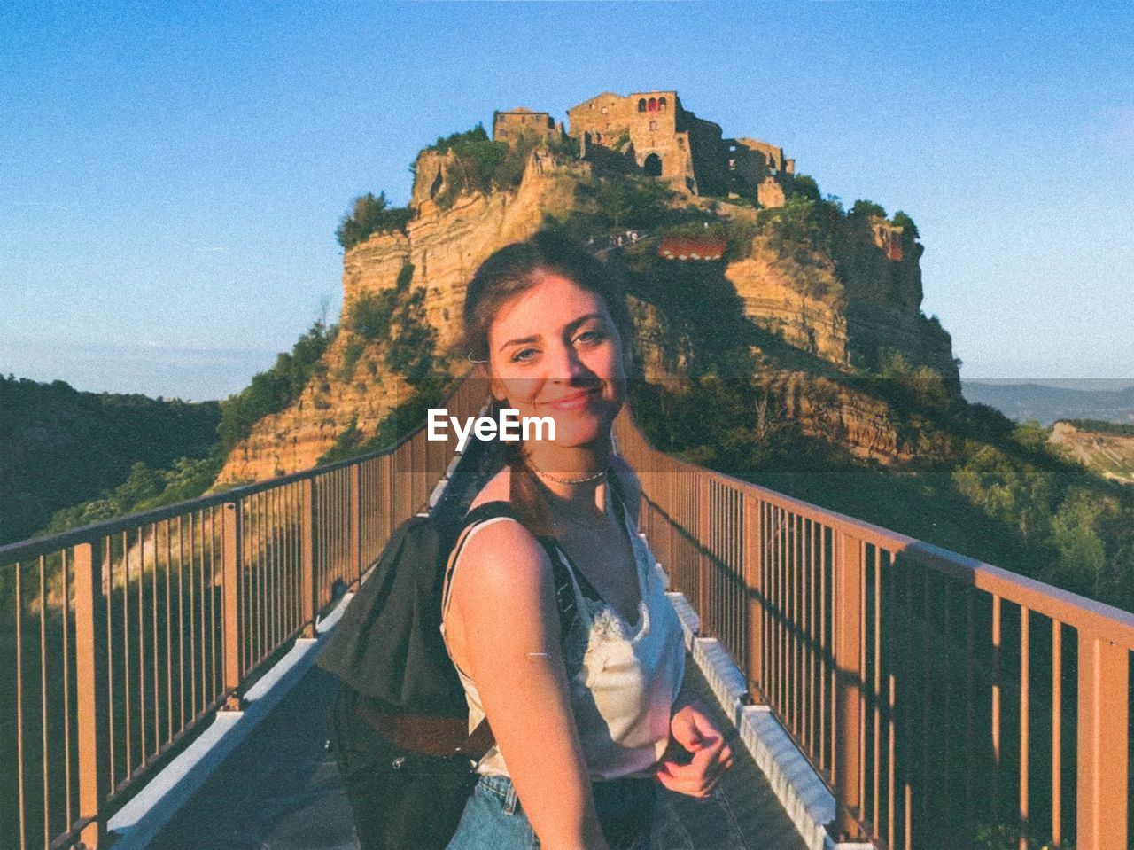 Portrait of smiling woman standing on bridge