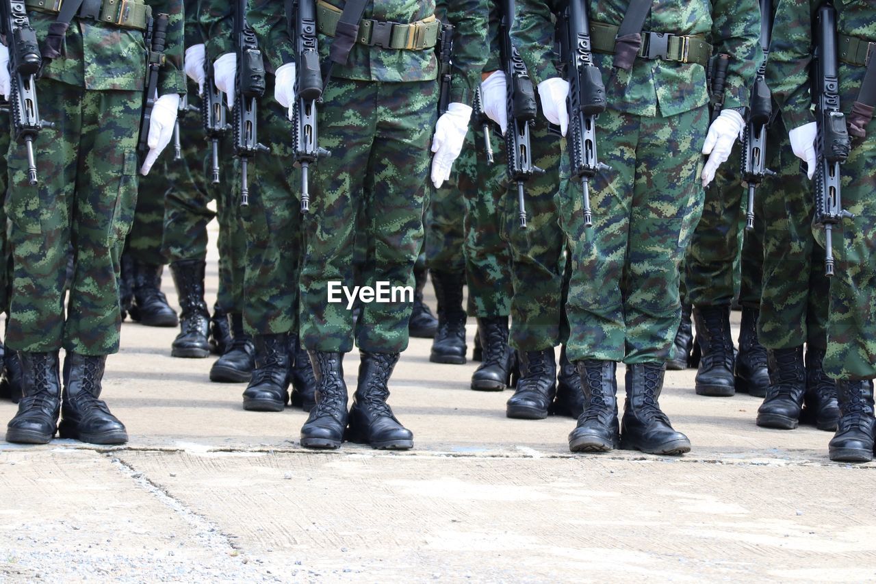 military, government, armed forces, uniform, military uniform, group of people, security, soldier, army, clothing, in a row, military parade, protection, camouflage clothing, marching, parade, person, weapon, crowd, large group of people, day, gun, outdoors, men, low section, standing