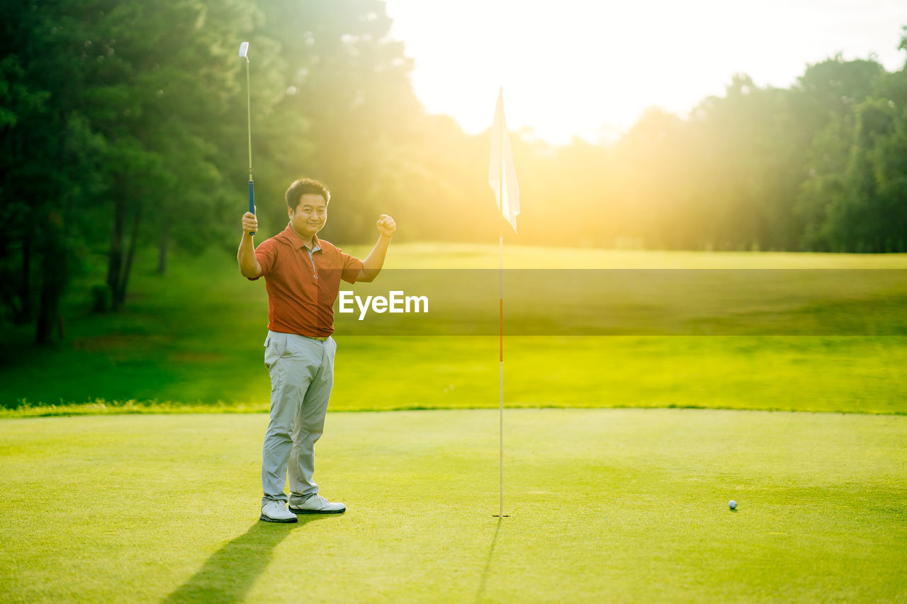 FULL LENGTH OF BOY PLAYING WITH GOLF COURSE