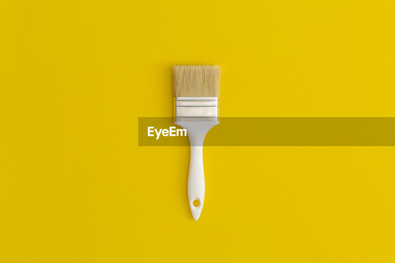 Paint brush on yellow background.