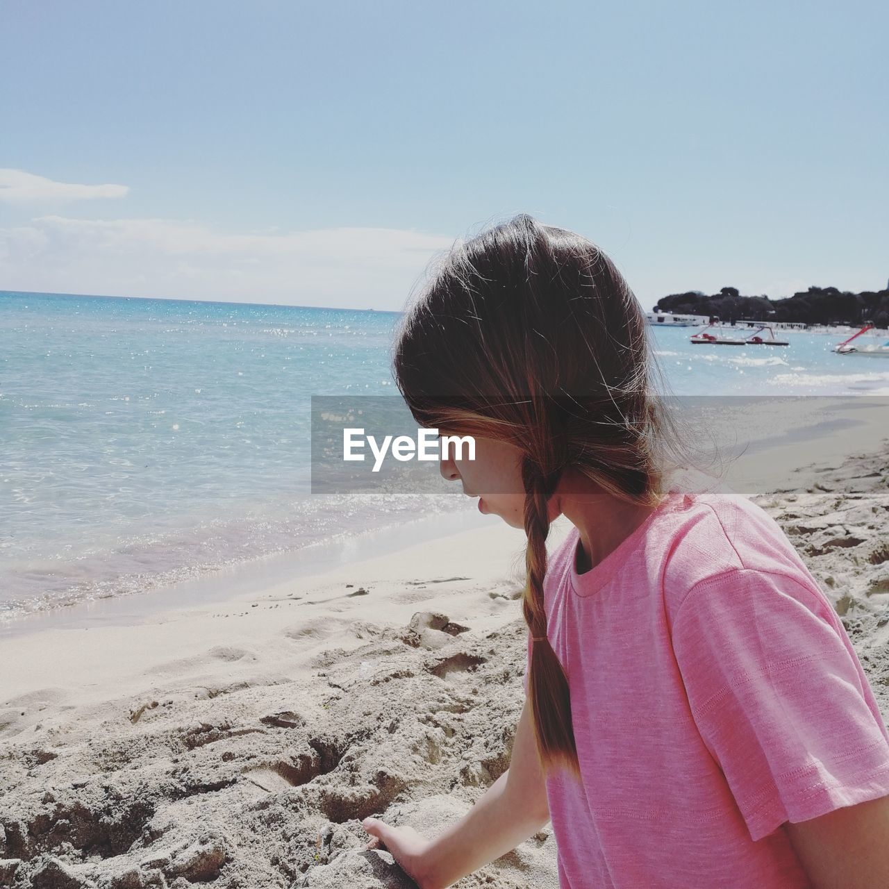 Side view of girl standing at beach against sky