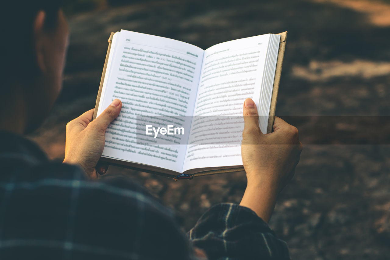 LOW SECTION OF WOMAN READING BOOK