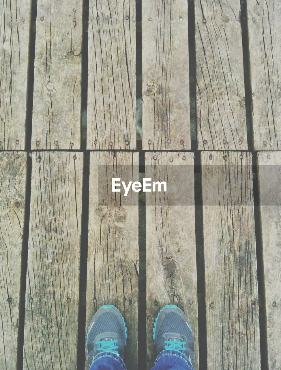 High angle view of person standing on wooden floor