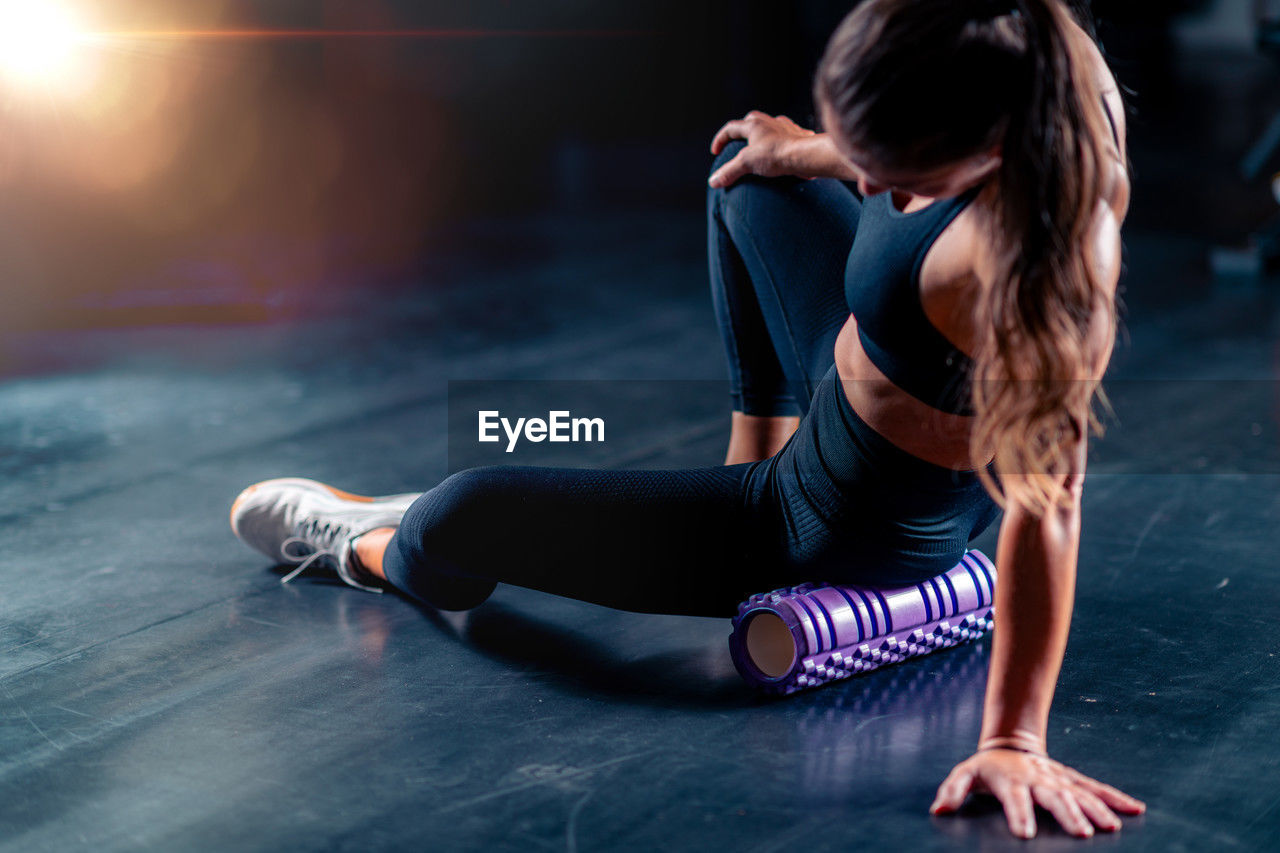 side view of woman sitting on floor